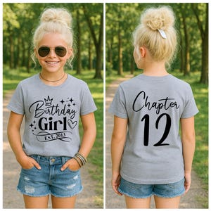 May include: A gray t-shirt with the text "Birthday Girl" and "Est. 2013" in black script, with a crown and stars design. The back of the shirt says "Chapter 12". The person is wearing denim shorts and sunglasses.