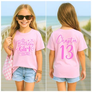 May include: A pink t-shirt with the text "Birthday Girl" and "Est. 2012" in a script font. The back of the shirt says "Chapter 13". The girl is wearing sunglasses and denim shorts. A pink and white checkered tote bag is in her hand.