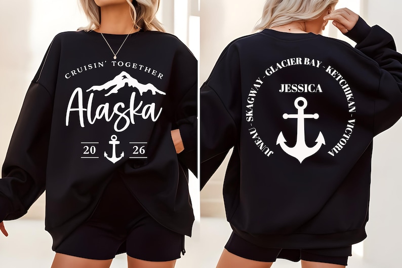 Puede incluir: Sudadera negra con texto gr&aacute;fico blanco y dise&ntilde;o de ancla. La parte delantera dice "Cruisin' Together Alaska 2026" con un gr&aacute;fico de monta&ntilde;a. La parte trasera presenta un dise&ntilde;o circular con "Jessica" y un ancla, rodeado de nombres de ciudades.