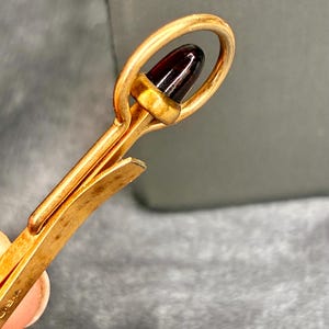Gold filled Krementz tie bar with gemstone accent.
