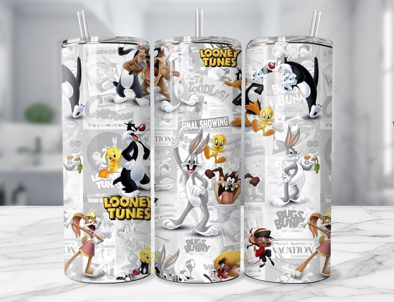 May include: Three stainless steel tumblers with Looney Tunes characters printed on them. The tumblers feature Bugs Bunny, Daffy Duck, Sylvester, Tweety Bird, and other characters. The background has a newspaper-like design with the words "Looney Tunes".