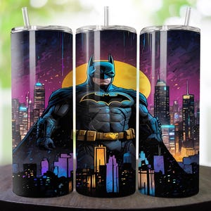 May include: A set of three stainless steel tumblers featuring a Batman design. The artwork depicts Batman standing in front of a cityscape with a yellow moon in the background. The tumblers have a black and blue color scheme with a straw.