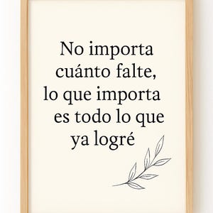 May include: A framed print featuring Spanish text: "No importa cuánto falte, lo que importa es todo lo que ya logré." The print has a cream background, black text, and a small leaf illustration. The frame is light brown.