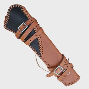 May include: A brown leather quiver with black accents and decorative stitching. The quiver features adjustable leather straps with silver buckles. The design is suitable for archery and outdoor activities.