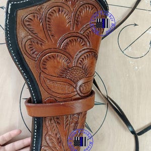 Pode incluir: Uma coldre de couro marrom com intrincados desenhos florais. O coldre apresenta uma borda preta com costura branca e uma presilha de cinto marrom. Uma al&ccedil;a preta est&aacute; presa. O texto "III Feel Free Duty will Pay By Seller !!! Purchase now.." &eacute; vis&iacute;vel.