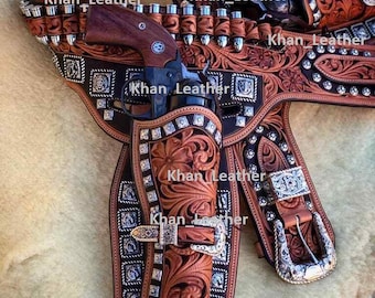 May include: A handcrafted leather gun holster set with intricate floral and geometric tooling. The set includes a revolver, bullet loops, and decorative silver-toned accents. The text "Khan_Leather" is visible on the holster.