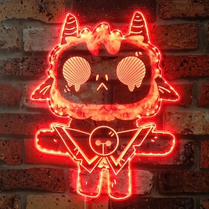 May include: A red neon light in the shape of a cartoon character with a round head, horns, and a body. The light is mounted on a brick wall. The character's eyes are striped, and the light has a power cord.