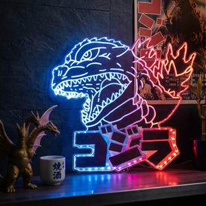 Puede incluir: Un letrero de neón con el monstruo Godzilla en azul y rojo. El letrero tiene la forma de la cabeza de Godzilla y los caracteres japoneses de Godzilla. Un póster de la película de Godzilla vintage está en el fondo.