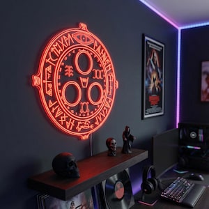 May include: A red neon sign in the shape of a circular emblem with symbols and text, mounted on a dark grey wall. A shelf below displays a skull, figurines, and vinyl records. A poster and computer setup are visible in the background.