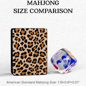The image is a comparison of the size of a Mah Jongg card and a dice, with the card being leopard print and the dice being clear with blue and red dots.
