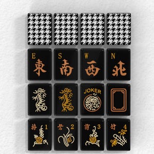 a collection of black and white checkered tiles with various designs and symbols, including winds, dragons, and a joker.