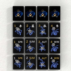 a collection of black tiles with various floral designs and numbers on them, arranged in a grid pattern.
