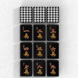 nine tiles, each with a unique design and number, arranged in a grid pattern. The tiles feature a combination of black and white houndstooth patterns and Chinese characters.