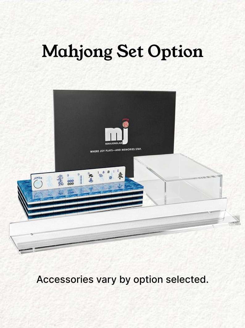 a set of Mah Jongg tiles and accessories, including a black box with the Mah Jongg logo and text, a stack of blue tiles, and a clear plastic case. The text above the image reads "Mahjong Set Option" and below the image, it states "Accessories vary by option selected."