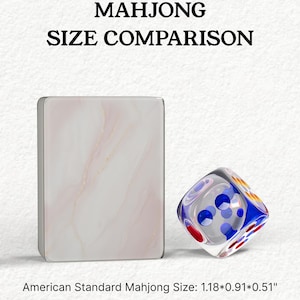 The image is a comparison of the size of a Mah Jong tile and a dice, with the tile being larger than the dice.