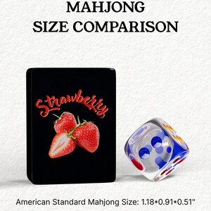 The image is a comparison of the size of a card with a strawberry and a dice. The card has a strawberry design, and the dice has a blue and white design. The card is labeled as "American Standard Mahjong Size: 1.18*0.91*0.51", indicating that the card is 1.18 inches by 0.91 inches, and the dice is 1.18 inches by 0.91 inches.