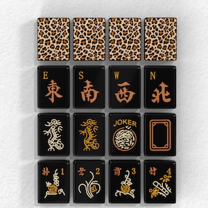 a collection of black tiles with various designs and patterns, including leopard print, Chinese characters, and the word "JOKER".