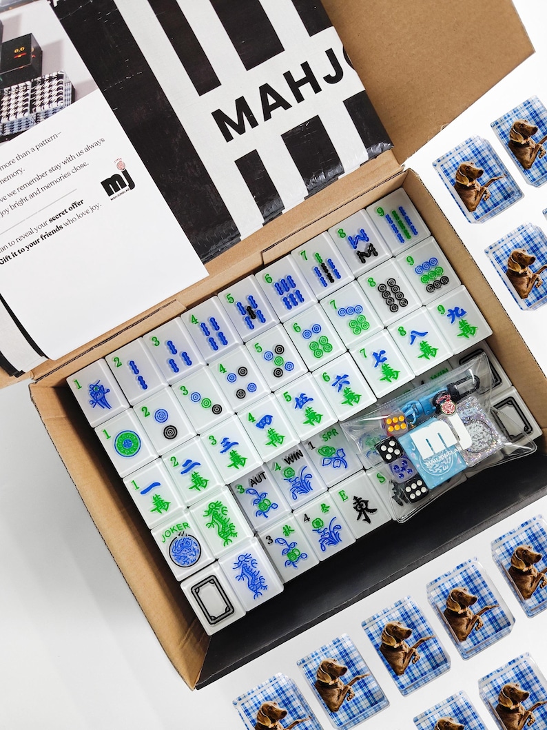 a box containing a set of mahjong tiles and a set of playing cards, both in a cardboard box.