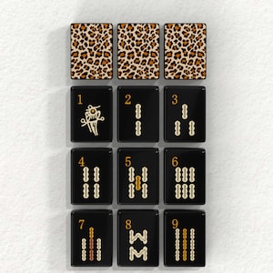 nine tiles, each with a unique design or pattern, arranged in a grid-like pattern. The tiles are black and have a leopard print or cheetah print pattern on them.