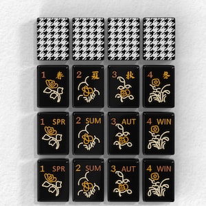 a collection of black and white tiles with floral designs, arranged in a grid pattern.