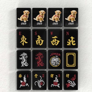 a collection of black and gold tiles with various symbols and designs, including images of dogs, dragons, and a joker.
