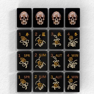 a collection of black tiles with gold designs, each tile featuring a different flower and number. The tiles are arranged in a grid pattern, with four rows and three columns.