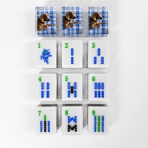 nine square tiles arranged in a 3x3 grid, each featuring a different animal and number combination.