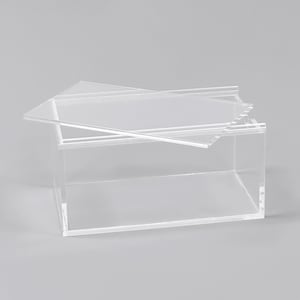 A clear, rectangular box with a lid, sitting on a plain surface.
