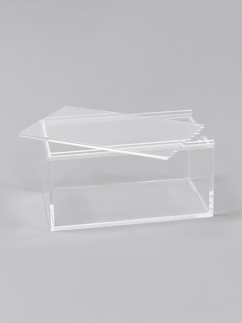 A clear, rectangular box with a lid, sitting on a plain surface.
