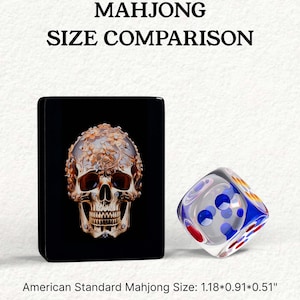 The image is a comparison of the size of a Mah Jong tile and a dice, with the Mah Jong tile being larger than the dice.