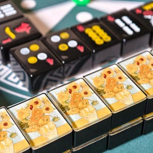 a close-up view of a stack of small, square-shaped metal containers with a floral design on them, placed on a table.