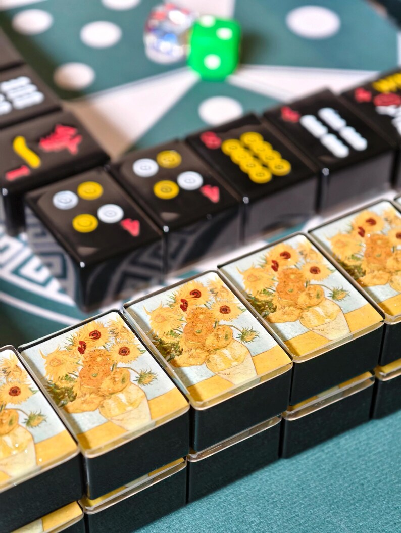 a close-up view of a stack of small, square-shaped metal containers with a floral design on them, placed on a table.