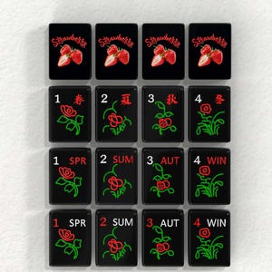 a collection of black tiles with red and green designs, each tile featuring a different flower or plant. The tiles are arranged in a grid pattern, with four rows and three columns.