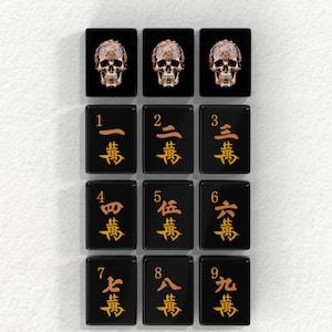a grid of black tiles with gold characters and numbers, arranged in a 3x3 grid.