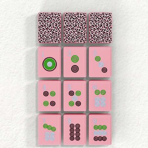 The image is a collage of nine tiles, each with a unique design, arranged in a 3x3 grid. The tiles are pink and feature various patterns and shapes, including leopard print, polka dots, and geometric designs.