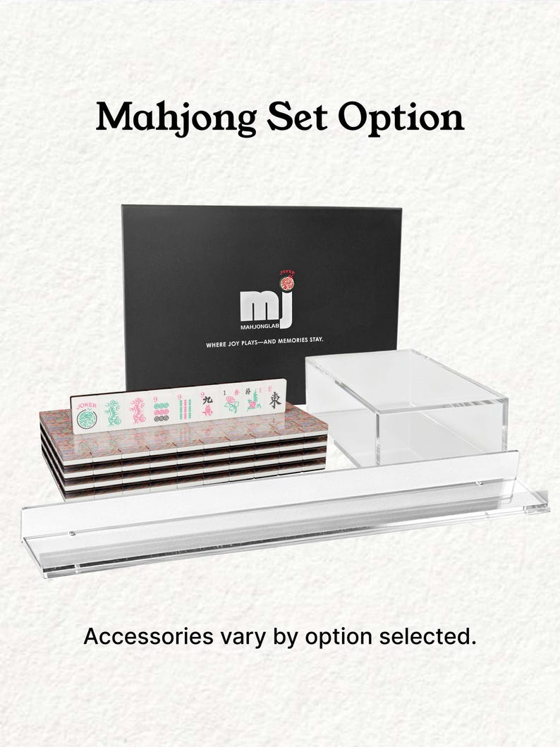 a set of mahjong tiles and accessories, including a black box with the mahjong logo and text, a stack of tiles, and a clear glass display case.
