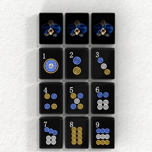 a collection of black tiles with various designs and numbers on them, arranged in a grid pattern.