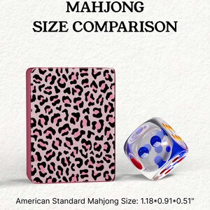 a pink leopard print object and a clear glass dice, both placed on a white background.