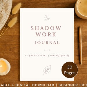 May include: A journal with the words "SHADOW WORK JOURNAL" in mauve lettering. The cover also includes the text "a space to meet yourself gently" and "30 Pages". A cup of coffee, pen, and candle are on a wooden surface.