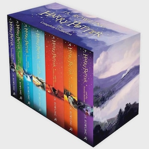 May include: A complete collection of seven Harry Potter books by J.K. Rowling housed in a decorative box set. The spines feature a gradient of colors including purple, green, teal, light blue, red, orange, and violet with gold lettering and illustrations.