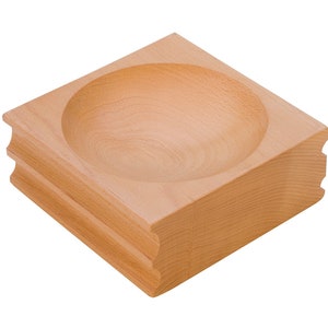 Puede incluir: Un cuenco de madera marrón claro con fondo redondeado y base cuadrada. El cuenco está hecho de madera y tiene un acabado liso.