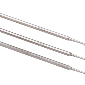 May include: Three silver dental tools with textured handles. The tools have different shapes at the ends, including a hook and a pointed tip.