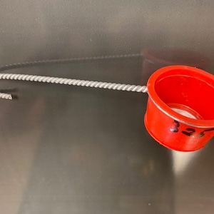 May include: A red plastic strainer with a metal handle and a mesh filter. The strainer is labeled "127".