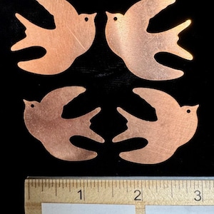 Pode incluir: Quatro recortes de pássaros de metal de cor cobre, cada um com aproximadamente 5 cm de largura, dispostos em um padrão quadrado. Os pássaros estão voltados para dentro, com as asas abertas. Uma régua é visível na parte inferior da imagem, com o texto "Enamelwarehouse.etsy.com" impresso nela.