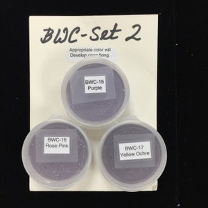 May include: Three small containers of purple clay, labeled "BWC-15 Purple", "BWC-16 Rose Pink", and "BWC-17 Yellow Ochre". The containers are arranged in a triangle shape on a white background. The text "BWC-Set 2" is written at the top of the image.