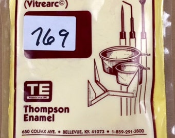 Op de afbeelding: Een gele zak met Thompson Enamel juweliers emaille voor metaal, met het label "Vitrearc" en "769". De zak is op een witte achtergrond met een rode rand. Het logo en de contactgegevens van het bedrijf zijn op de zak gedrukt.
