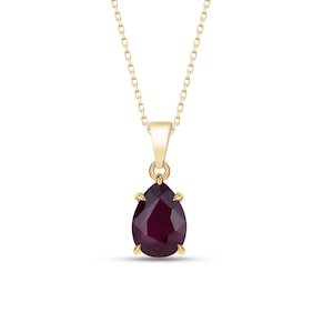 Könnte beinhalten: Eine goldfarbene Halskette mit einem tropfenförmigen, tiefroten Edelsteinanhänger. Der Anhänger hängt an einer zarten Kette und schafft ein klassisches und elegantes Schmuckstück. Der Edelstein ist etwa 2,5 cm lang.