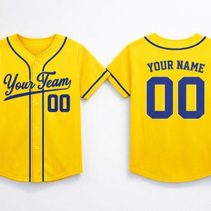 Peut inclure: Maillot de baseball jaune avec des détails bleu marine. Le devant affiche "Your Team" et le numéro "00". Le dos présente "YOUR NAME" au-dessus du numéro "00". Le maillot a une fermeture boutonnée et des manches courtes.
