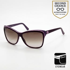 Puede incluir: Gafas de sol moradas con lentes degradadas. Las monturas son de color morado oscuro con un acento morado más claro. Las lentes hacen una transición de marrón a un tono más claro. El texto "SECOND CHANCE AUTHENTICATORS VERIFY THE VISION" es visible.