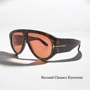 Może przedstawiać: Brązowe okulary przeciwsłoneczne w wzór szylkretu z soczewkami w kolorze brzoskwiniowym. Okulary mają grubą oprawkę i złoty metalowy akcent na zausznikach. Tekst "TOM FORD" jest widoczny na soczewce. Poniżej okulary tekst "Second Chance Eyewear".